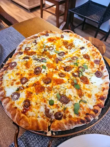 Pizza servida sobre a mesa na Casa de Tia