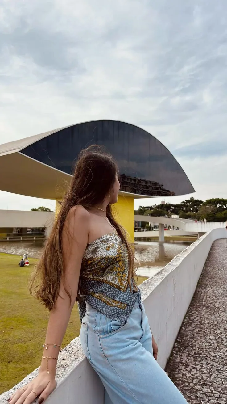 Pessoa de perfil com o edifício do Olho ao fundo